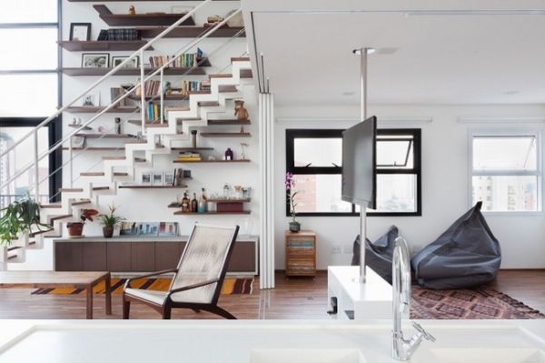 开放式厨房、挑高的客厅，这是位在巴西圣保罗的楼中楼，由建筑师Isabel Nassif与Renata Pedrosa所成立的Sub Estúdio设计的作品，在5.5米的挑高空间里重新塑造出屋主夫妻的生活方式，电视机设定在可旋转钢管上，不论在做菜或是坐在沙发上都能看，楼梯旁一整面的置物架颇为壮观，巧妙的填充了大面墙壁的空白，一举两得。
