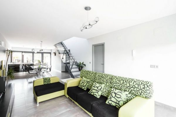 这个优雅现代的住宅位于西班牙，由Viraje Arquitectura.于2013年完成设计。室内采用了经典的现代设计风格，灰白色墙面、地板、楼梯、门窗，整个空间简约大气，而客厅翠绿色的沙发给室内增添了无限的生机。
