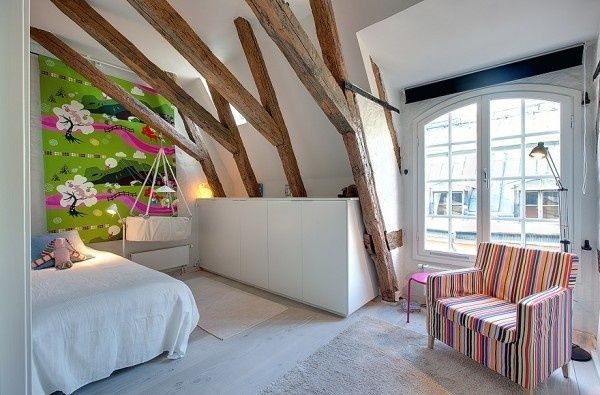 这座独特的阁楼公寓位于瑞典斯德哥尔摩的Gamla Stan老城区，它融合了旧时的文化元素与现代的设计手法。开敞宽阔的居住空间，最鲜明的特点在于别致的裸露木梁和坚固的松木地板，带有别致斜撑梁的宽敞卧室为众多房间带来了欢快的氛围。软装时尚、舒适、清新自然，十分的温馨又现代化，十分“不搭调”的原木却穿插在整所房子中，似乎穿越了古今，来混搭主人的房子，现代的小配饰和挂画点亮了整个空间，合理的布局和色彩的搭配，都让人觉得舒适自然。