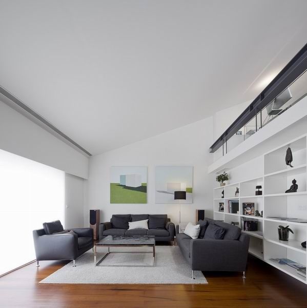 该位于葡萄牙里斯的挑高阁楼,屋主希望在增加空间功能性的同时保持原来的通透和明亮，设计师以白色为底，与灰黑色搭配尽显简约、低调，同时不失现代风，材质良好的木质材料让空间更显质感，稳重又舒适。