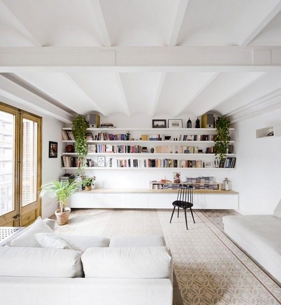 西班牙设计师Anna和Eugeni Bach于2013年完成了对这间住宅的改造项目。住宅面积1206平方英尺，原先分割的两个空间合为一体，保留了部分传统的家饰，亦添置新的装饰物，使得传统与现代在这间公寓中相得益彰。白色的主色调、原木色的地板和门窗、橱柜，令人感受到家的温馨。
