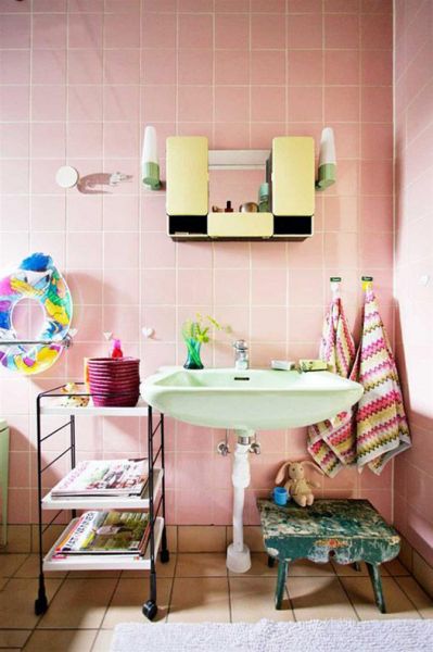 我们可以注意到这张浴室案例的马卡龙元素主要体现在浴室的瓷砖上，虽然只有单一的淡粉色，但是通过其他的一些如毛巾、编织篮、花瓶等物的衬托，让整间浴室犹如缀满饰物的甜点一样。