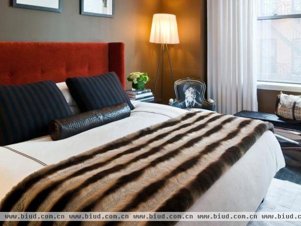 卧室散发着一种酒店式的味道，还有一股阳刚氛围，红色床头板及软垫，再配上清脆的床上用品和温暖的墙壁颜色。不喜欢都难。