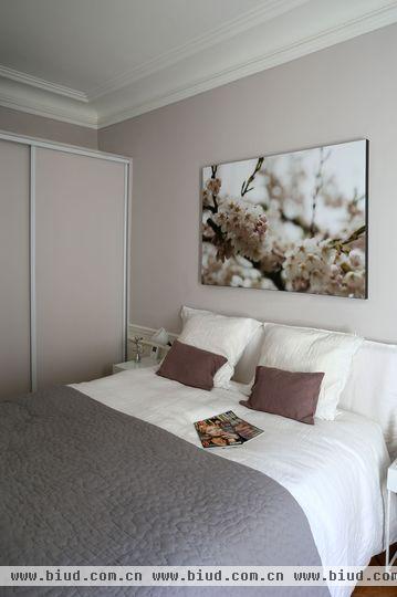 主卧设计依旧保持极简主义，淡粉色的墙壁给人一种温暖和淡雅的感觉。