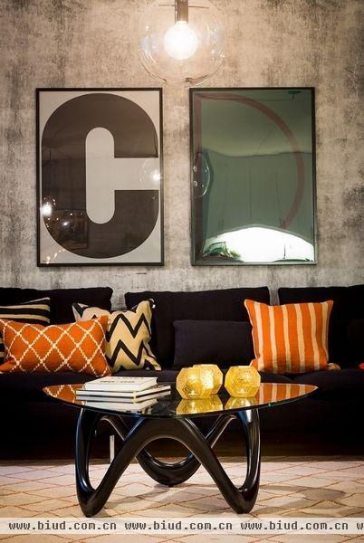 现代时尚感的圆面茶几，橙色抱枕作为点缀，为灰色调的空间增添几分活泼元素，倒也显得时尚起来。