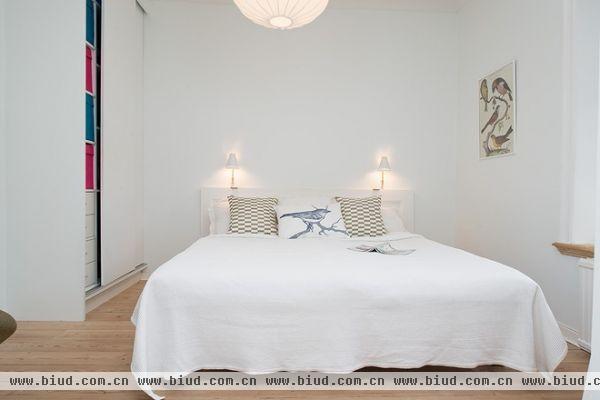 卧室是雅致的白色，精致的飘窗带着软软的靠枕还有一盆翠绿色的小植。