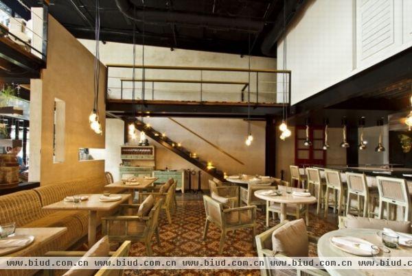 位于墨西哥梅里达最繁华的一条街市，设计师专门设计了一个特别的主题餐厅，不像一些零售的空间一样花里胡哨但是缺少内涵。设计引起墨西哥知名的厨师的注意。厨房展示厅就和用餐者是在一起的，这也是设计的最重要的一部分。进门的墙是用天然的鼠尾草树脂和混凝土混合而成的材料做成的。向前几步就到了高天花板的主用餐厅，映入眼帘的是混凝土地板、橙色意面的地毯以及两层高的石墙。楼上有另外两个聚会场所，一个是面对主用餐区，一个是可以欣赏露台风景的。开放式的厨房吧台用石块做成，表面透明的玻璃顶与其对比鲜明。夹层和房顶有很明显的区别，钢架结构漆成黑色，木头墙和地板都是精心挑选的。