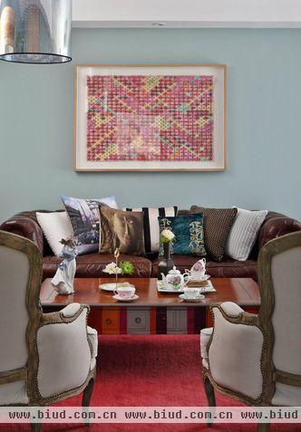 设计师为客厅增添了一块亮丽的枚红色地毯和相同色系的挂画，既达到平衡与呼应，更增添了室内温暖友好的气氛；鲜艳的视觉刺激令谈话充满亲和力与创造力。