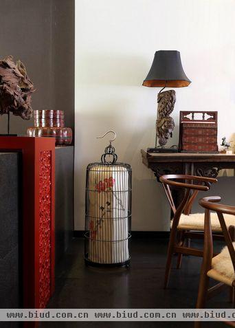 在一楼的客厅和餐厅,只用1.1米高的烧毛面中国黑石材搭上了以古代剔漆工艺为灵感设计而成的红漆边桌作为隔断，保证了光线的延续的同时使空间更有层次感。