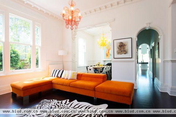 一楼的天花板漆上大面积的白，搭配地板的黑，以黑白经典配色作为风格主调。而选择彩度高的橘色，作为点缀空间的主要色系，像是客厅的沙发与造型吊灯、厨房的开放壁柜，中岛的橘线吊灯，与餐厅的双色吊灯；而二楼则是运用更多鲜艳色彩，将色彩与艺术品完美结合，除了丰富空间也增添趣味。喜欢耀眼夺目的鲜艳色彩吗？试着先从头上那片天开始吧！
