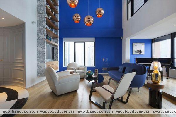 正如其名，工作室展示出占主导地位的蓝色配色，这间位于上海的惊人复式公寓设计成围绕中心的通向主卧室区的螺旋式楼梯。高高的天花板悬在客厅中，社交空间被想象成用其体积和空隙塑造生活空间。在客厅的上方的空间，主书房提供了工作场所，同时又可以不忽视掉楼下发生的家庭生活厨房和用餐空间同在一室，旁边吧台安装在墙壁上，并用玻璃封闭。室内展示的色彩搭配很值得借鉴，这家豪华的复式公寓提出了自己的经典与现代之间的组合。细节营造出独特的生活环境，从而使之成为一处令人赞叹的空间，你觉得呢？