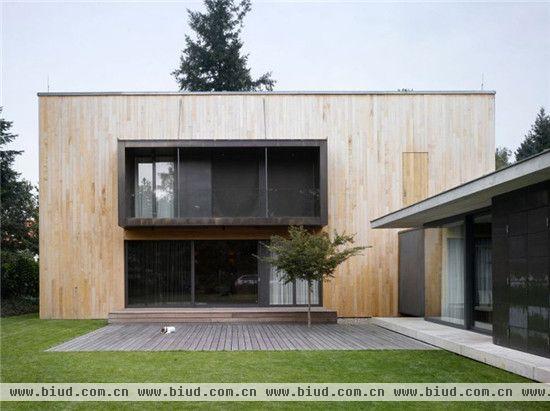 这幢干净朴素的木质家庭住宅位于捷克，由设计事务所Studio Pha设计完成，住宅由两个相互交叉衔接的建筑体量构成，呈“L”形。住宅地处一片开阔的基地上，周边有郁郁葱葱的植被和草坪，为了使住宅能与周边环境有一个良好的互动，住宅首层的设计十分强调开放性和透明度。其中单层体量的建筑为住宅的生活区，是通透明亮的玻璃结构，充足的自然光照，流动清新的空气，充分利用了大自然对人类的馈赠，这个空间连接起车库。而两层建筑体量的木质结构像是车顶行李架，依次是卧室、浴室及相关比较私密的空间，室内依然是原木包裹的墙面地板，温暖舒适，一条短短的走廊连接将两个建筑体量连接了起来。