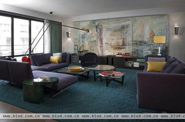 以突出的色彩拼接让人耳目一新， 蓝绿色的地毯，紫色的沙发，鲜艳的红色配饰，冲突碰撞产生了强烈的视觉效果，带有灵魂的设计，强调舒适感，突出艺术性。