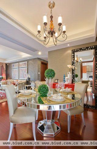 银白色的餐桌上放的一处绿色的植物为整个空间做了一个点缀，餐桌和餐椅摆放有序，餐厅里有着低调奢华的美。