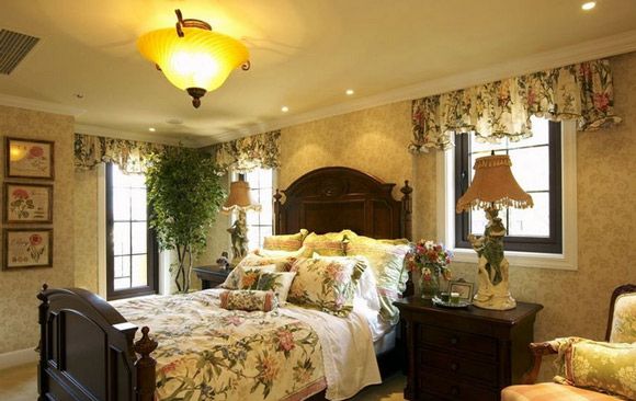 深色的厨具给人沉稳的厚重感，床上用品和窗帘用的都是花纹系列的，室内的植物正好与被单的花纹相对应，黄色的灯光照的更加温馨和谐。