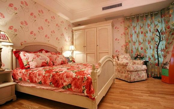 整个卧室是红花满天飞啊，背景墙，床上用品，沙发，窗帘都是花纹系列，用的是原木色的地板，白色的衣柜和床具很搭配。