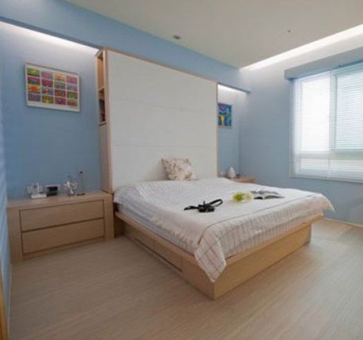 看到这个天蓝色背景墙的卧室有种很放松的感觉，卧室里很有层次感，家居布置简单。