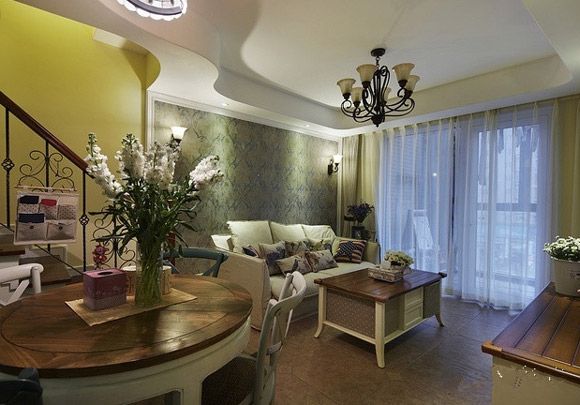 客厅的空虽有点小却很精致，简单的家居摆设营造了和谐的家居氛围，实木的家居很适合美式风格，淡紫色的窗帘带有一种温馨浪漫的视觉效果。