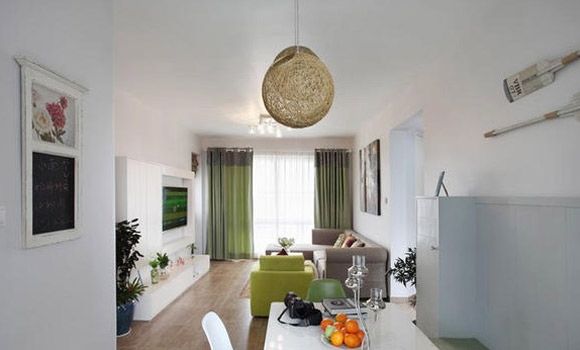一眼看去整个客厅了四白落地，映入眼帘的最多的是白色和绿色，四面通透的设计，简单的线条和家居摆设，精美的球形吊灯，整个客厅展现一种自然的氛围。