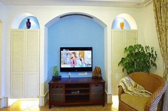 藤编椅透露出了屋主对自然的田园生活的向往，蓝色的拱形门电视背景墙有种时尚浪漫的气息，充满了奇特的异域风情。