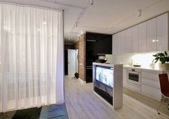厨房与卧室之间有一个窄窄的走道，中间用了一个玻璃门做间隔，四周用的是白色的纱窗，至于那个紫色的光芒就是电视的光线问题了，这种设计在现代家装里来看还是比较特别的。