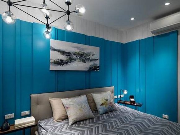 设计师很大胆的用海蓝色做卧室的背景墙，床头上方还挂了一幅水墨画，很有立体感的吊灯使整个空间一点也不显单调。