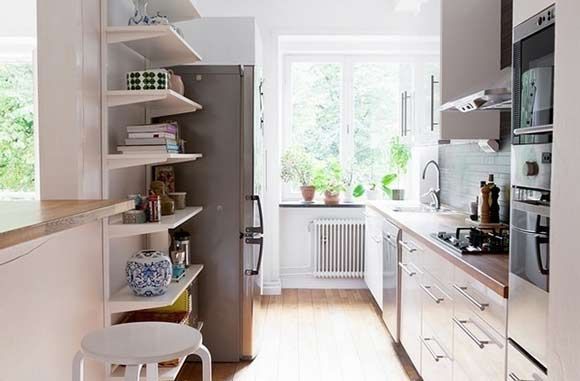 白色的橱柜能让整个厨房显得干净清爽，实木的台面，显得整个家装风格都很时尚大方，窗台上的绿植使整个厨房都显得清新自然，且采光较好。