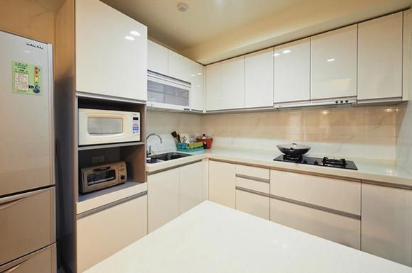 L型的厨房，利用转角可以很好的节省空间，又能将烹饪区和清洗区独立的分隔开来，形成一个完美的工作区域，白色的整体橱柜，大理石的台面，给人一种纯净空灵的感觉，下面的一排地柜和上面的一排吊柜可以很方便的做收纳，这样的空间打扫起来也很方便。