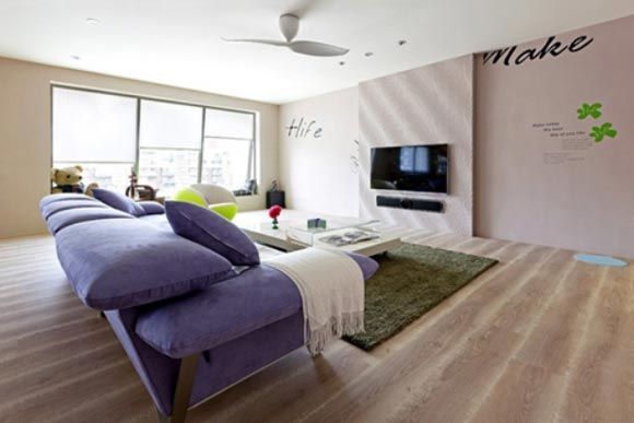 沙发的紫色系成为视觉重点，加上墙面面壁贴的巧妙规划，形成随性的居家样貌。