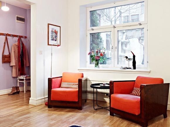 客厅的另一面放着两张橘色沙发，色彩亮丽。