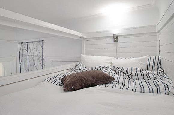 床铺的外侧利用透明的塑料隔板作隔断，有效地保障了安全的同时也不妨碍光线透入，床头灯的设计也是十分贴心，木纹背景墙更是提升了睡眠空间的质感。