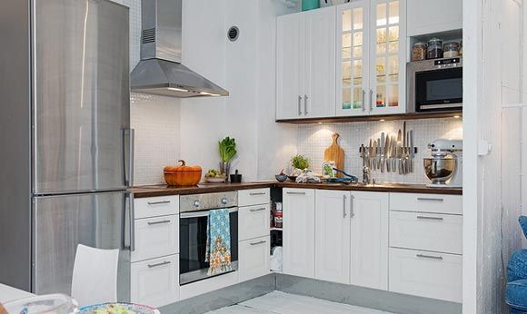 开放式厨房，顶吸式油烟机，木工板与彩色地毯使厨房与客厅的空间得以划分。