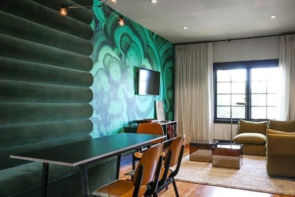 背景墙运用了大胆的绿色抽象图案让人眼前一亮 ，简单的边几和沙发搭配铁制明窗复古典雅。