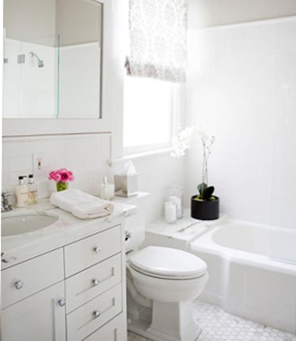 把卫浴的储物柜置于洗手台下，充分地利用了闲置的空间，同时也方便了洗浴物品的存取。卫浴以白色为基调，空间显得开阔明亮，再加上鲜花的点缀，更易于放松神经。