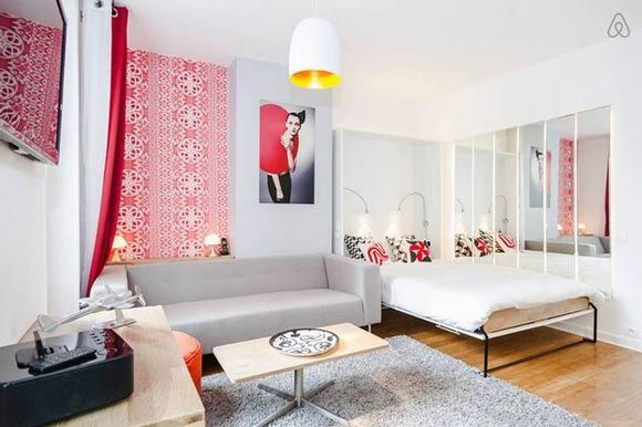 这是网站上刊登的一座巴黎公寓，开放式的设计让并不算大的空间显得十分明亮，白色为底，红色点缀，每一处都显得充满了活力。利用圆弧形的家具灯饰，让空间温润舒适，两盏吊灯简单又可以制造气氛，虽然面积只有30平米，但是具备各种机能，也显得十分的适合居住。