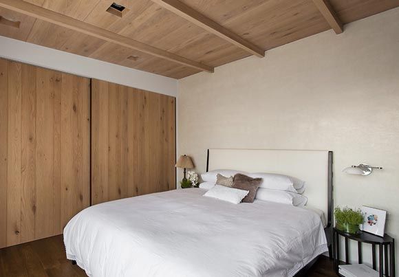 卧室简单得只剩下了纯白的大床与不加任何修饰的实木衣柜。