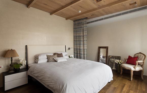 卧室简单得只剩下了纯白的大床与不加任何修饰的实木衣柜，加上一个窗帘，就是简易的换衣间。