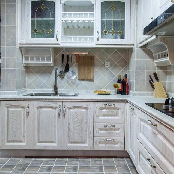 厨房是把生活阳台打通后做的U型厨房，橱柜是白色橡木的，墙地面砖，橱柜，吊灯，色彩都是相呼应的 灰白色调，非常的干净有品质。