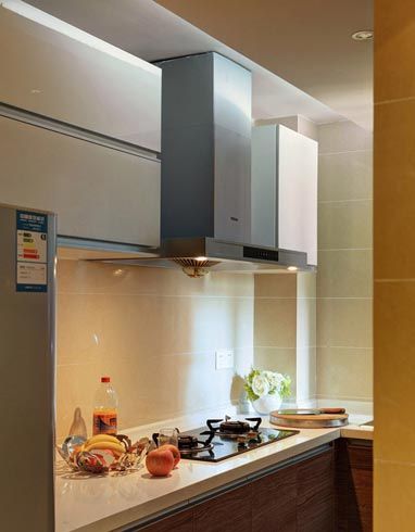 厨房空间的布局亦是简洁有力，宽敞的橱柜台面，上方的油烟机和碗柜，收纳空间充足。