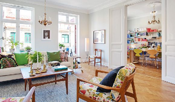 来看瑞典这间古典乡村风公寓吧！天花板与墙壁都漆上白色，与地板充满设计排列的木质地板。在采光与通风良好的空间中，更显得舒服宽敞。白色双人沙发，混搭浪漫风情的碎花椅垫木椅，古典的吊灯与烛台，透过简单的配件，让整体空间增加许多，只属于家的温度。