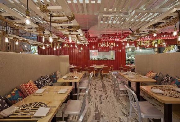 整个餐厅设计非常的丰富，入口处墙面的装饰画是一位秘鲁艺术家的作品“两个世界”，顶部的霓虹灯也采用了秘鲁南部风格的线条。继续走进，不仅有竹子围绕的餐桌还有日式榻榻米。而整体的正红色则拥有浓厚的中国风，混搭的风格，充满了魔幻的色彩。