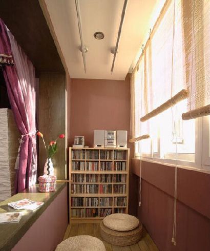 这间阳台在空间内放下了一个木质书架，可以收纳下不少平日爱看的书籍，在木质地板上随意的摆放上两个藤编小圆座，这间阳台就可以当作一个小小的阅读空间来使用，而一旁的隔断也是相当能体现出实用性的。