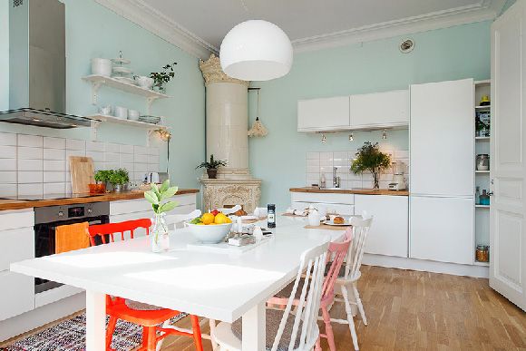 客厅的白色墙面与天花板都漆上白色，搭配温润的木质地板，就是最基本的简约风格。客厅的鸟笼吊灯，放上几只鲜艳的小鸟，让人有种置身丛林的错觉。而在采光良好的厨房，漆上粉蓝色的墙面，白色的餐桌，混搭粉色及红色的餐椅，让用餐空间多了分活泼的氛围。来看看瑞典这间马卡龙风公寓吧！