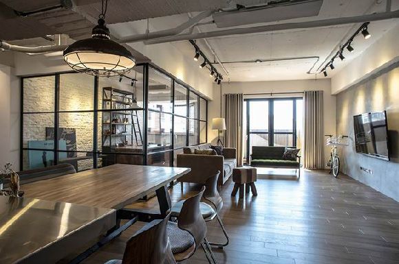 屋主夫妻都是工程师，结束一天的工作后十分希望可以回到一个轻松如咖啡馆般的空间中，为了让空间更为宽敞不压抑，设计师重新改造空间，用黑框玻璃代替原先厨房的额墙壁，增加通透感，而整个空间区域摆放了两个木长桌，复古木质更加塑造了咖啡馆的宁静和清闲，经过处理的清水混凝土墙面和地面让空间本质暴露在外，体现最原始的质感。