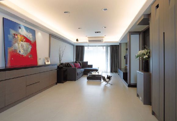 客厅空间随着尺寸的改变在视觉上的比例也随之变化为长方形，加上柔和的大地色系相当搭配，银色表布与黑橡木染白的框体，提高空间的稳重性，悠然闲适的气味于焉产生。