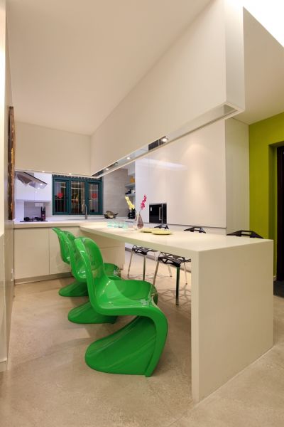 餐桌的设计也很有特点，两边选择了完全不同的两种椅子，一遍是绿色的塑料椅子，另一边是黑色的铁艺椅，和整体的“黑绿对比”相呼应。