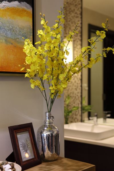 颜色十分跳跃的黄色跳舞兰，与墙壁上的画作相得益彰，让整个客厅从素色的设计中解放出来，更添了些许春的意境。