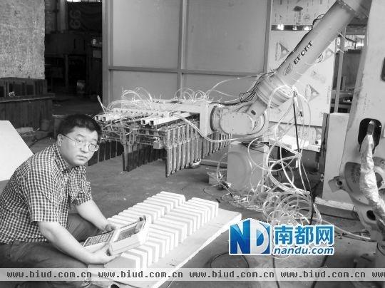 </p><p>秦磊和他发明的四工位喷釉机器人系统。 通讯员供图</p><p>