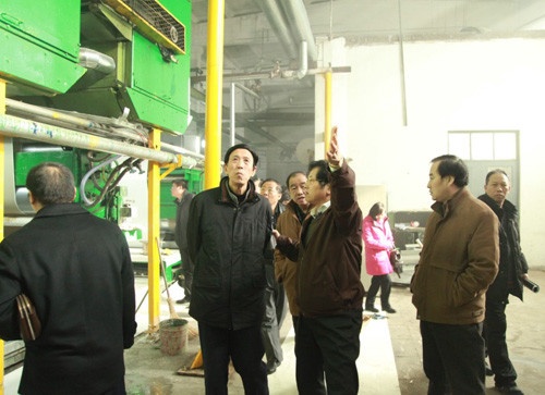 图为：特普丽董事长杨冀(左三)带理事会成员参观墙纸生产线