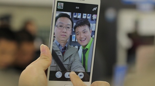 幸运街采：深圳小伙成功升级一部大屏幕智能手机，高兴地与主持人合影留念